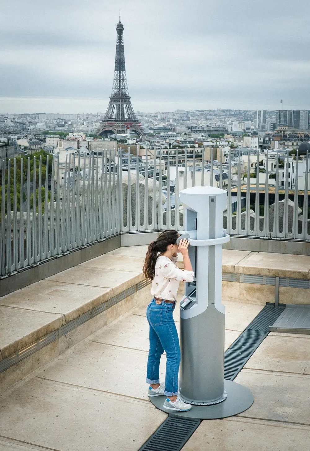 Una visitante ante la cabina Timescope, con la torre Eiffel al fondo © Matthieu Perrot