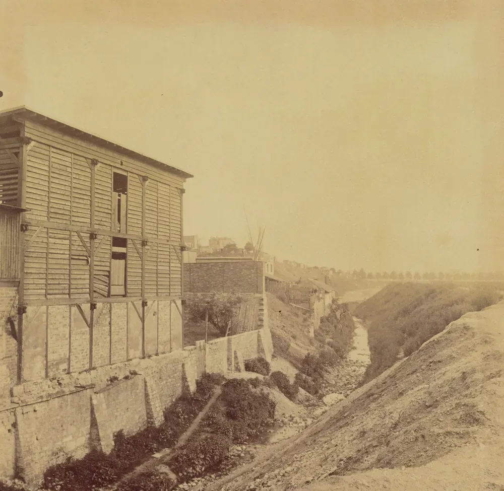 Photograph by Eugène Atget: the Bièvre on boulevard d'Italie in 1898, a dark stream lined with tannery buildings, shortly before it was covered over