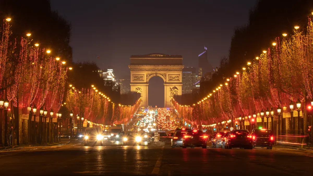 The avenue des Champs-Élysées at night with its trees lit for Christmas, looking up towards the Arc de Triomphe