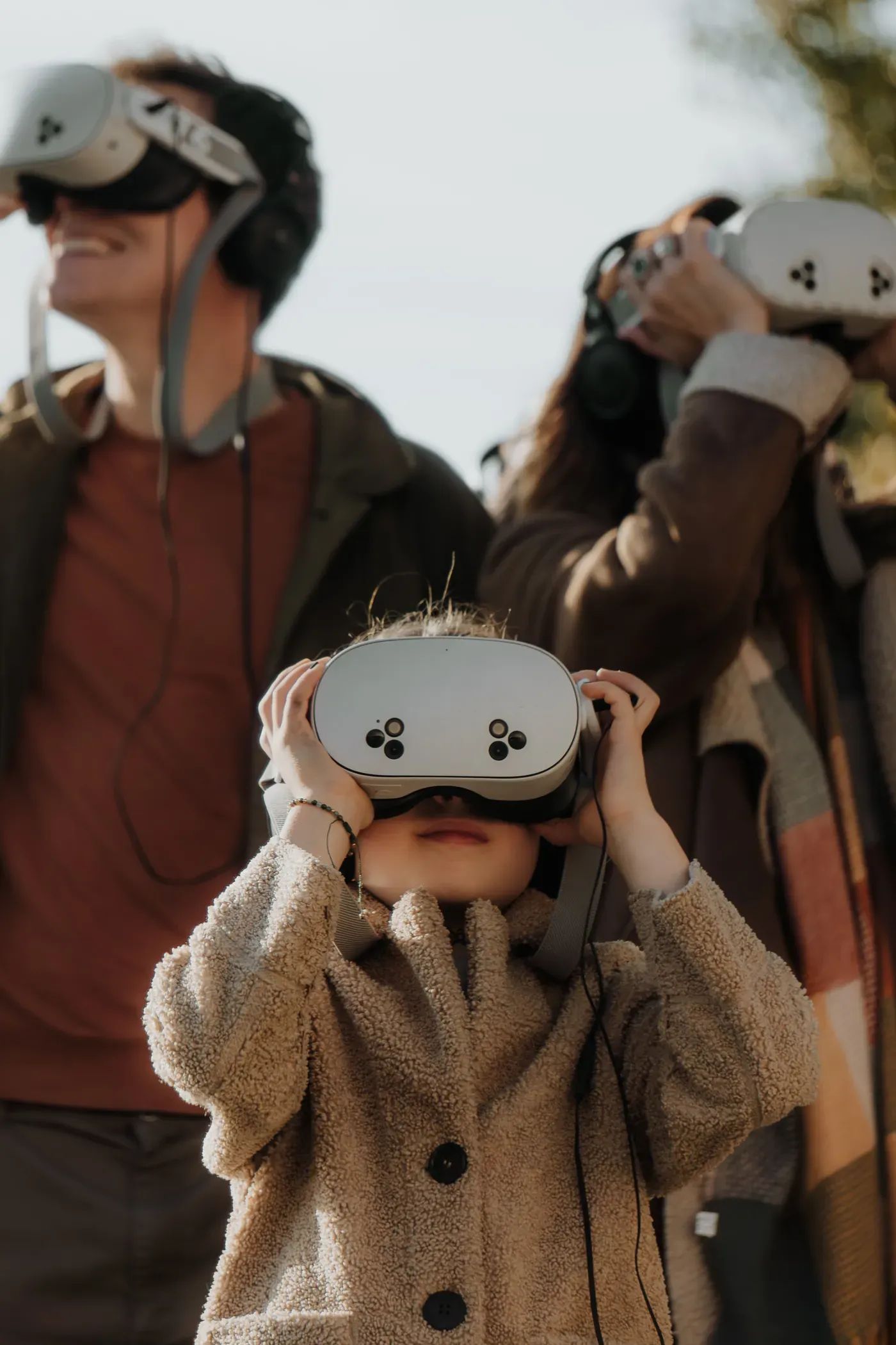 A child raises Timescope virtual-reality binoculars on the banks of the Seine, surrounded by the group
