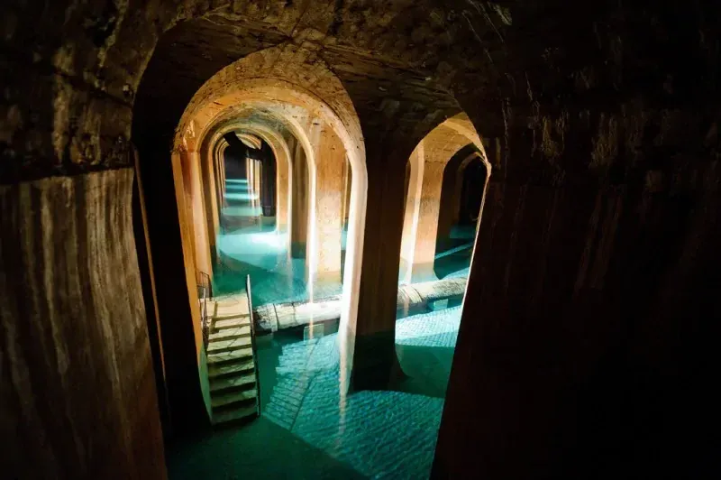 Le réservoir de Montsouris, arches et piliers de pierre au-dessus d'une eau turquoise