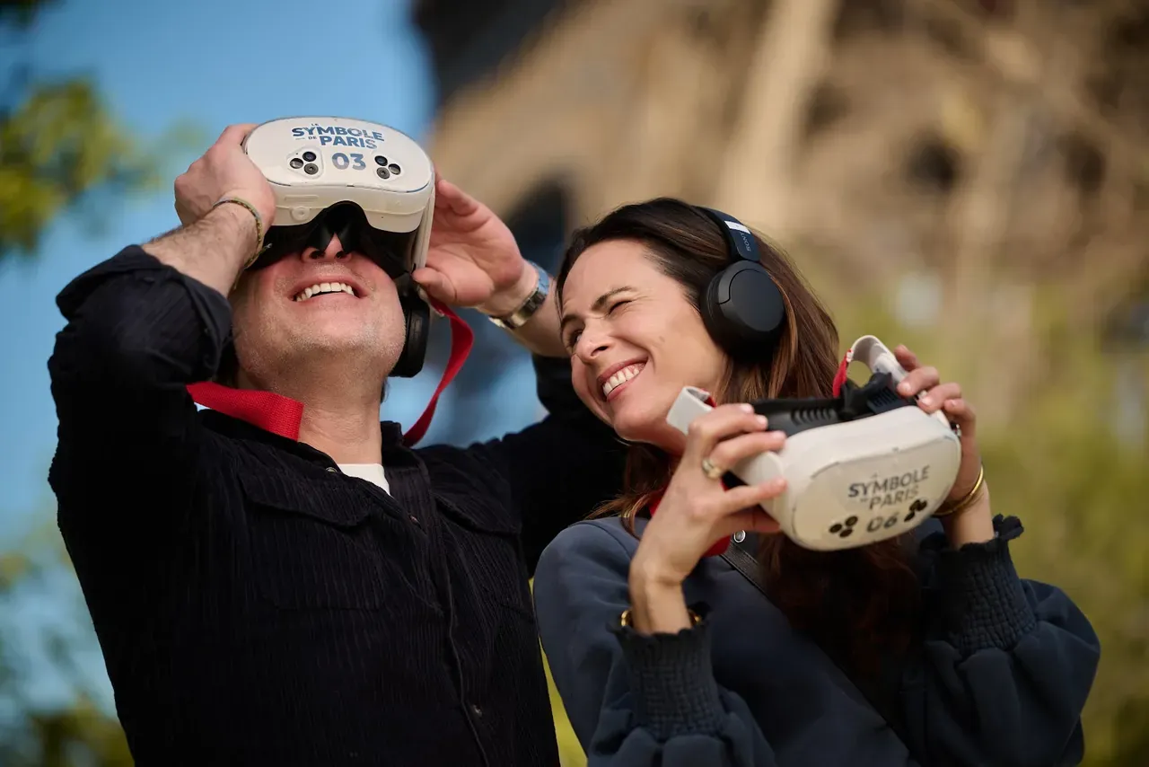 Un couple observe la Tour Eiffel en réalité virtuelle aux jumelles Timescope, sur le Champ-de-Mars