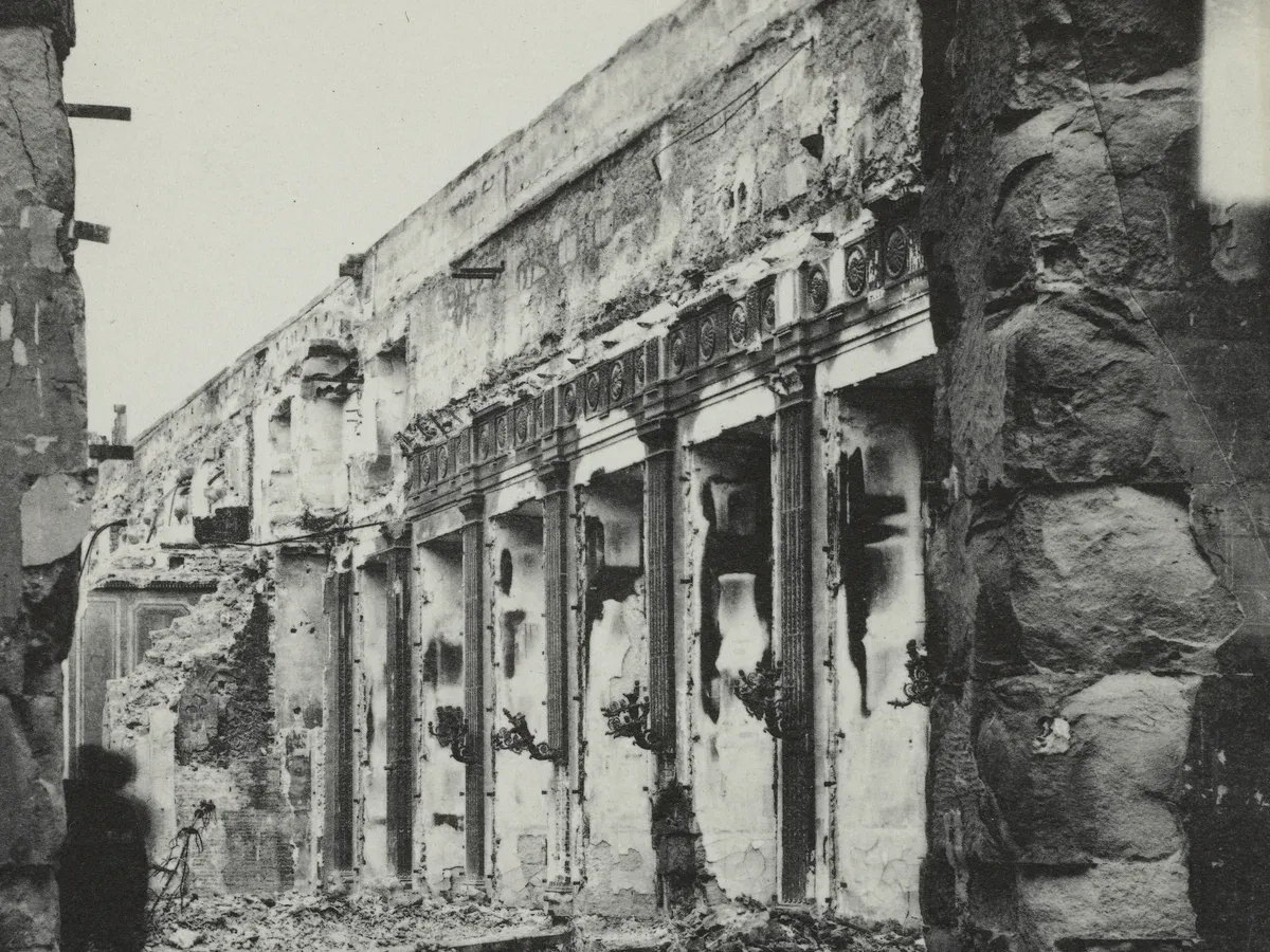 Un intérieur incendié du palais des Tuileries après 1871, boiseries brûlées et appliques pendantes, photographie d'époque