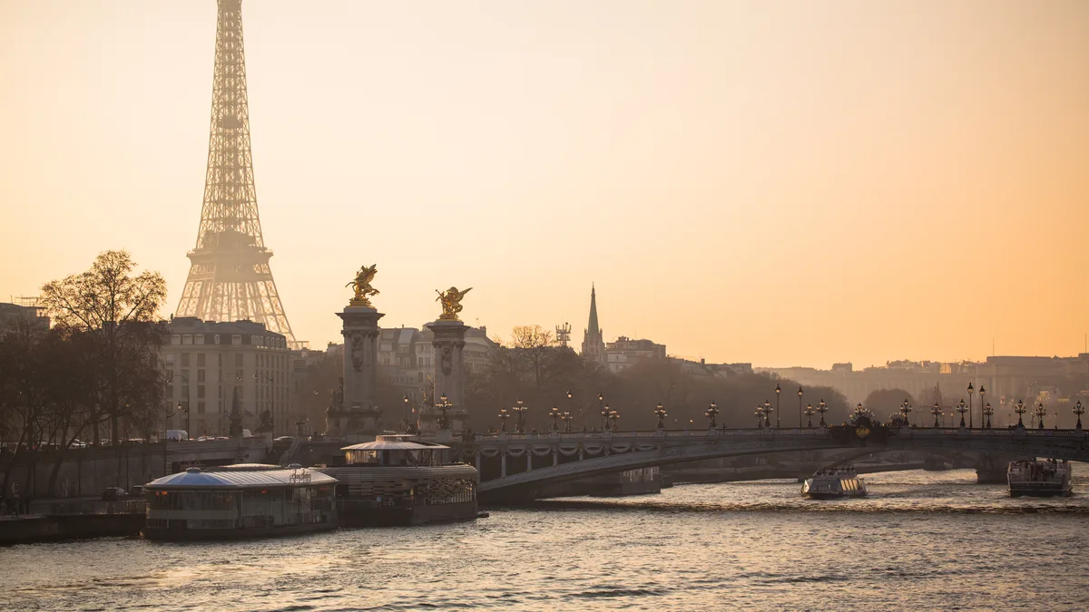 La Tour Eiffel et le pont Alexandre III dans la brume dorée d'un coucher de soleil d'hiver, vus depuis la Seine