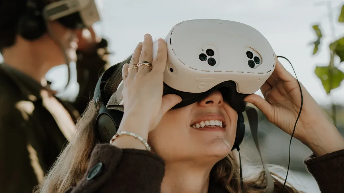Une jeune visiteuse soulève ses Jumelles de réalité virtuelle avec un grand sourire au bord de la Seine